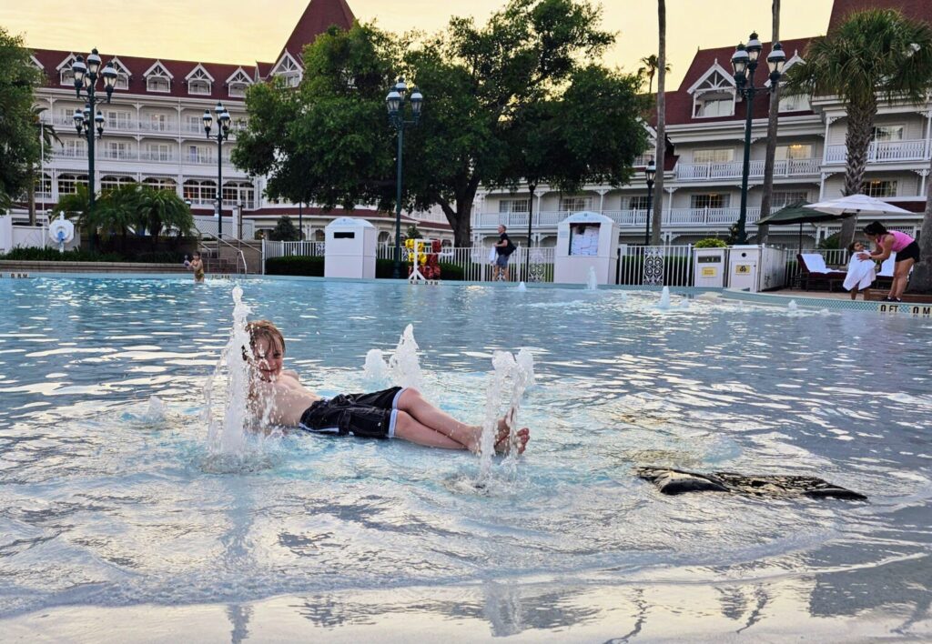A child playing in the pool at Disney's Grand Floridian resort. This photo is the featured image for a blog about family vacations and how to include children of all ages in the planning written by Heather Sparklestar